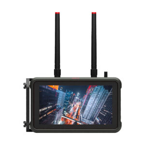 Atomos_Connect_002 ATOMOS Connect, kannettava videomonitori, jossa on kaksi mustaa antennia ja kestävä musta runko, näyttää yöllä kirkkaan ja kirkkaan kaupunkikuvan, jossa on valaistuja pilvenpiirtäjiä ja katuja korkealta katsottuna.