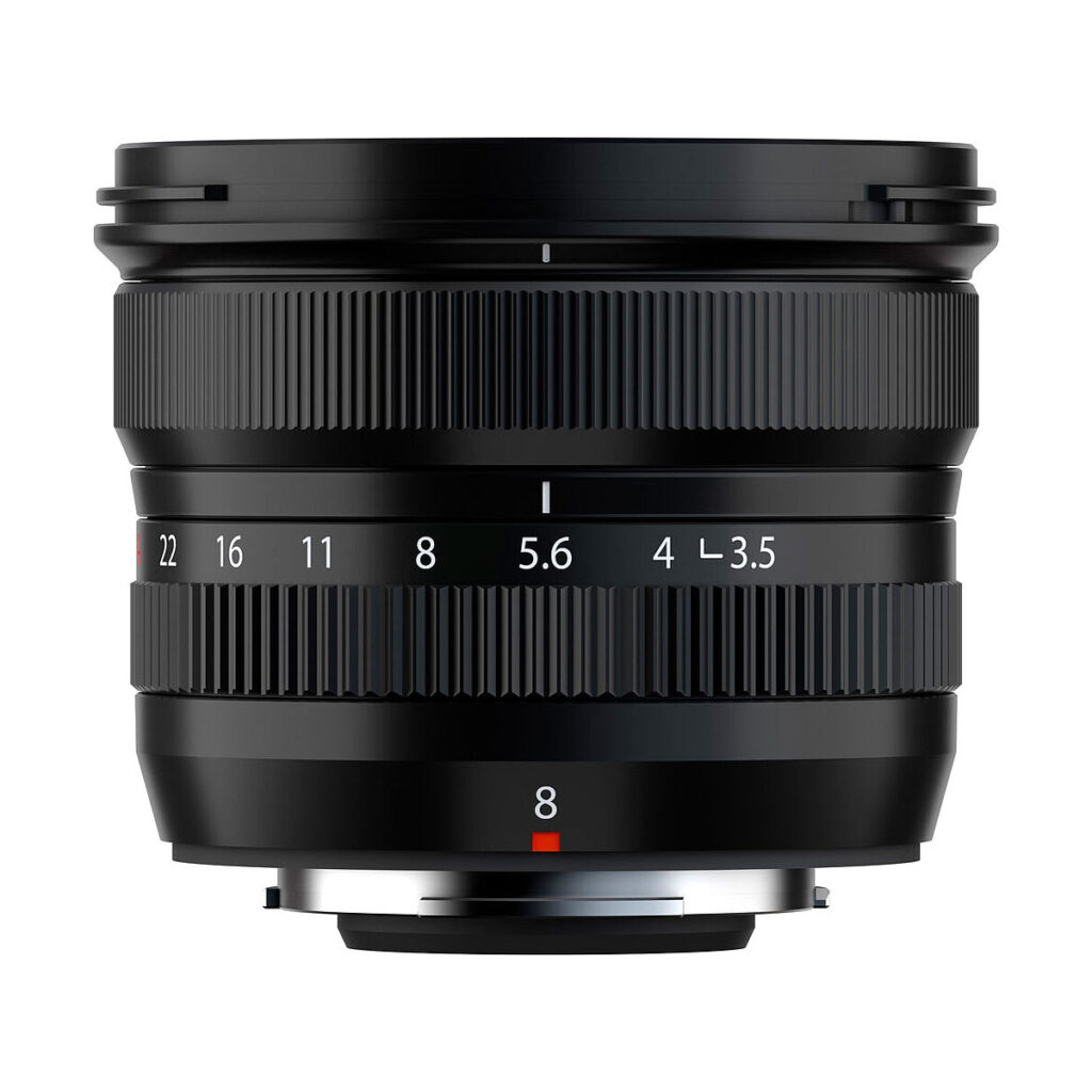 Fujifilm Fujinon XF 8mm f/3.5 R WR -objektiivissa on musta runko, kuvioidut tarkennus- ja aukkorenkaat, valkoiset aukkomerkinnät ja punainen kohdistuspiste valkoista taustaa vasten.