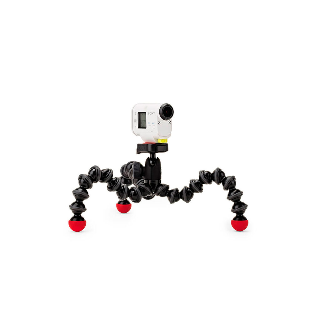 JOBY GorillaPod Action3 JOBY GorillaPod Action GoPro Jalusta, pieni valkoinen toimintakamera, joka on asennettu joustavaan mustaan jalustaan, jossa on neljä taipuisaa jalkaa ja punaiset kumijalat, näkyy tavallista valkoista taustaa vasten.