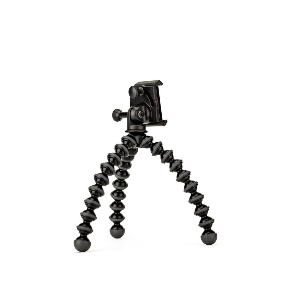 JOBY GripTight GorillaPod Stand PRO JOBY GripTight GorillaPod Stand PRO Jalusta Puhelimelle on pieni musta joustava kolmijalkainen jalusta, jossa on kolme taivutettavaa, segmentoitua jalkaa ja yläkiinnike älypuhelimen pitämiseen. Tausta on pelkkä valkoinen.
