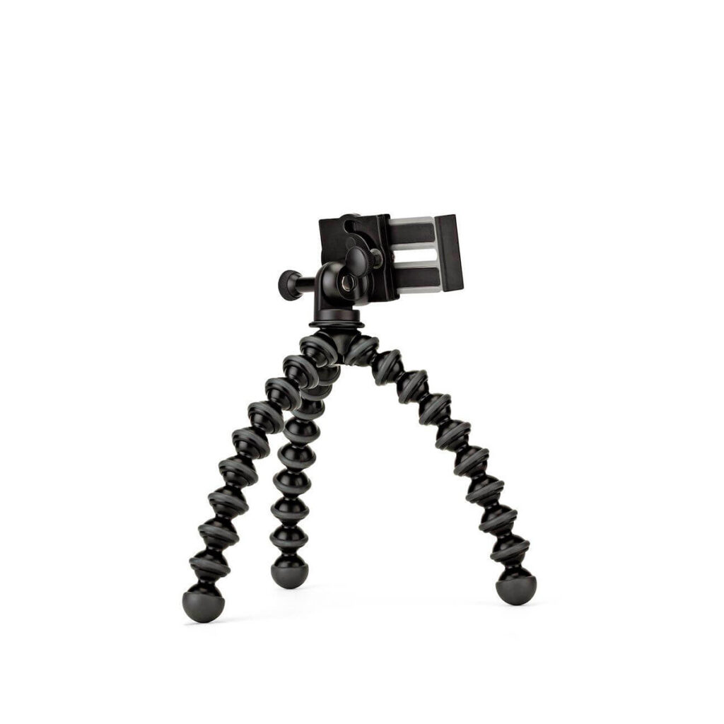 JOBY GripTight GorillaPod Stand PRO1 JOBY GripTight GorillaPod Stand PRO Jalusta Puhelimelle, joustava musta kolmijalka, jossa on taivutettavat jalat ja älypuhelimen pidike, seisoo pystyssä valkoisella pohjalla.