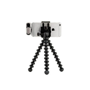 JOBY GripTight GorillaPod Stand PRO5 JOBY GripTight GorillaPod Stand PRO Jalusta Puhelimelle kiinnitetään älypuhelin, jossa on kiinnitettävä linssi, sen kolmelle joustavalle jalalle valkoista taustaa vasten.