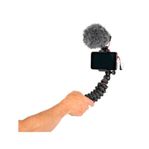 JOBY GripTight PRO 2 GorillaPod11 Käsi pitää JOBY GripTight PRO 2 GorillaPod Jalustakit Puhelimelle kiinnitetyn älypuhelimen, ulkoisen mikrofonin, jossa on karvainen tuulisuoja, ja kaapelit, jotka muodostavat kannettavan vloggausasetelman.