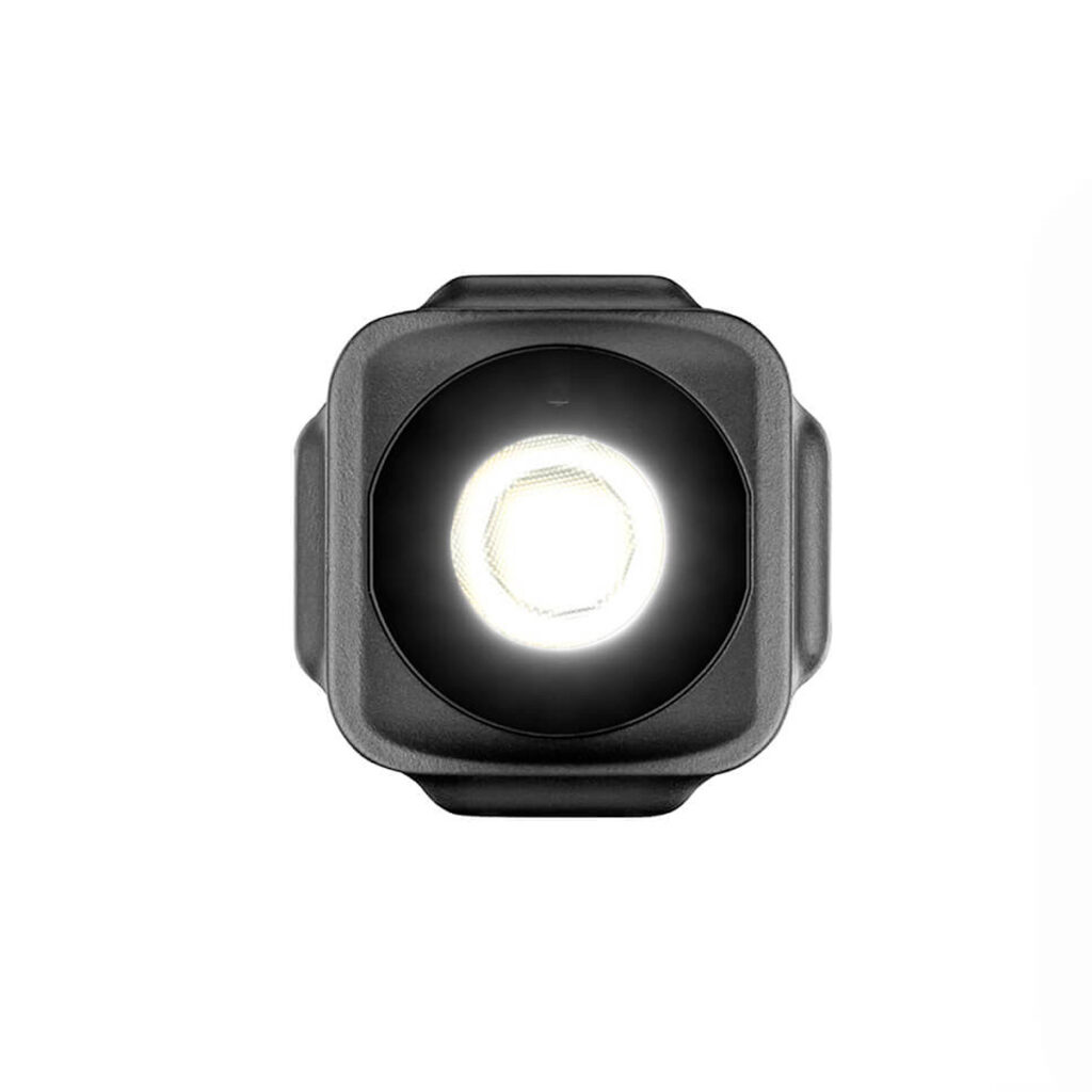 Joby-Beamo-Mini-2 Joby Beamo Mini - LED-valo on pieni, musta, neliönmuotoinen LED-valo, jossa on kirkas pyöreä keskipiste, joka näkyy edestä valkoista taustaa vasten.