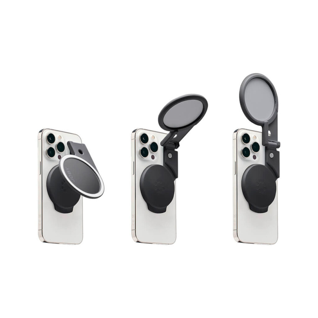 Joby-Beamo-Ring-Light-for-MagSafe-5 Kolmessa älypuhelimessa näkyy Joby Beamo Ring Light for MagSafe - Harmaa, joka on kiinnitetty kolmeen asentoon: suljettu, osittain avattu ja täysin avattu paljastaen sisällä olevan pyöreän peilin.