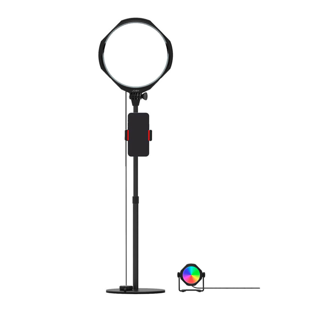 Joby-Beamo-Studio-Deluxe-Lighting-Kit Joby Beamo Studio Deluxe -valaisinsarjassa on rengasvalo säädettävällä jalustalla, jossa on keskellä älypuhelimen pidike, ja pieni, pyöreä RGB-LED-valo, jotka molemmat saavat virtansa kaapeleista.