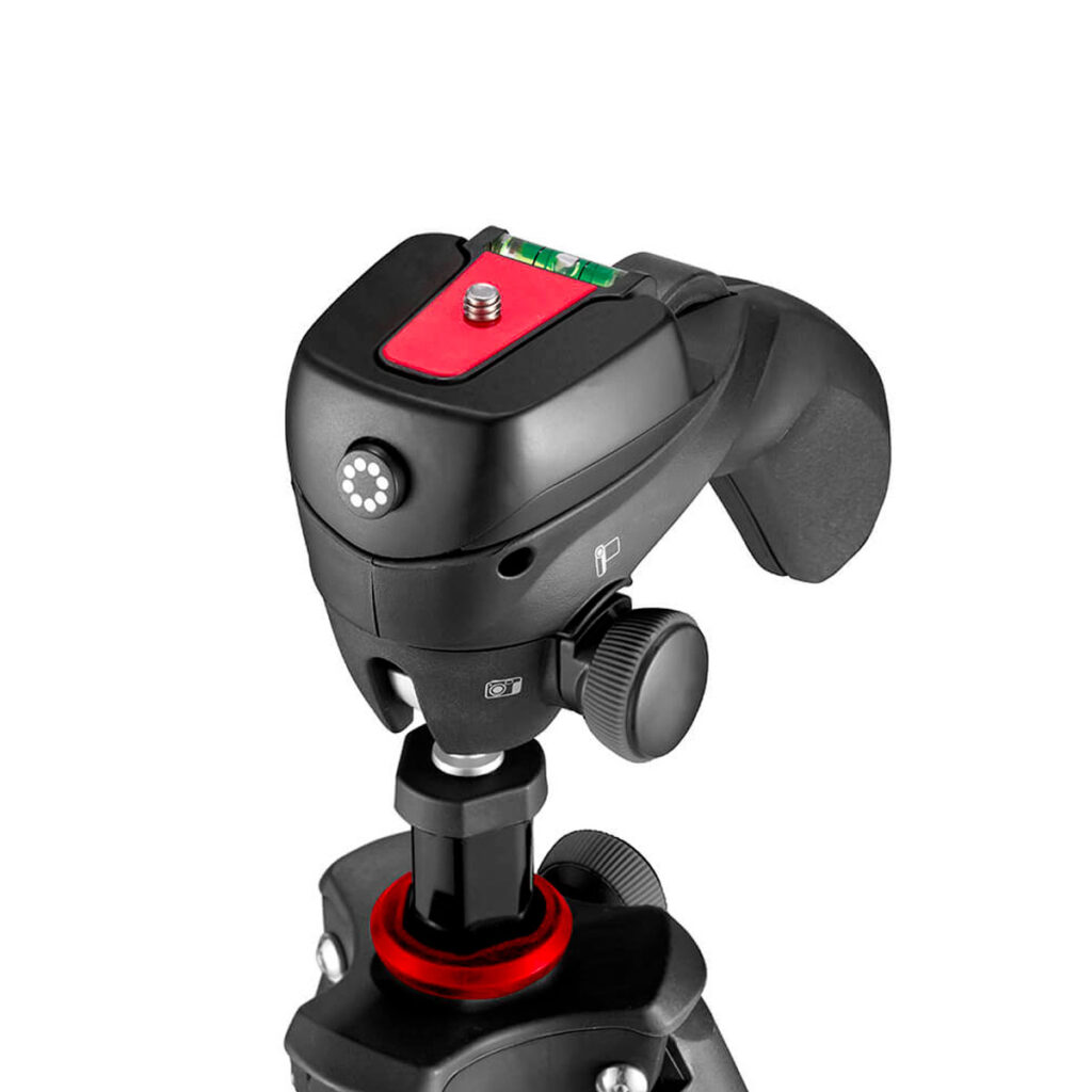 Joby-Compact-Action-3K-5 Close-up of the Joby Compact Action 3K tripod head, black and red, with adjustment knobs, built-in bubble level and quick release plate, mounted on a tripod base against a white background.