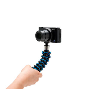 Joby-GorillaPod-Go-500-+-GripTight-360-Tripod-Kit-Blue-4 Käsi pitää kompaktia Sony-kameraa, joka on kiinnitetty Joby GorillaPod Go 500 + GripTight 360 Tripod Kit Blue -jalustaan, eristettynä valkoiselle taustalle.