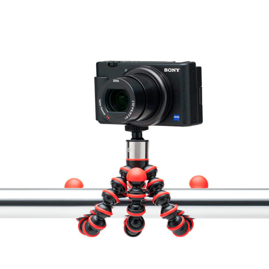 Joby-GorillaPod-Go-500-+-GripTight-360-Tripod-Kit-Red-4 Musta Sony-kamera on kiinnitetty Joby GorillaPod Go 500 + GripTight 360 Tripod Kit Red -jalustapakettiin, joka on kiedottu tukevasti vaakasuoran metallitolpan ympärille.