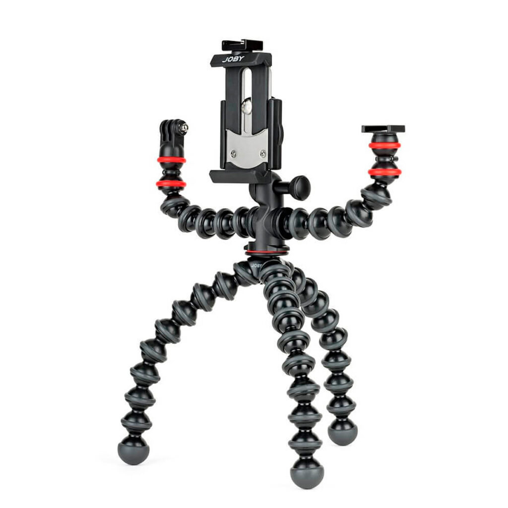Joby-GorillaPod-Mobile-Rig-3 Joby GorillaPod Mobile Rig on joustava musta kolmijalka, jossa on segmentoidut jalat, älypuhelimen pidike ja kaksi säädettävää käsivartta lisävarusteita varten, mikä korostaa sen taipuisaa muotoilua ja monipuolisia kiinnityspisteitä.