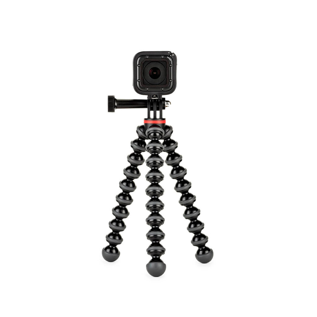 Joby Gorillapod 500 Action1 JOBY GorillaPod 500 Action Jalusta Musta/Harmaa, pieni musta toimintakamera, joka on asennettu sen joustaviin, segmentoituihin jalustajalkoihin, on aseteltu valkoista taustaa vasten.