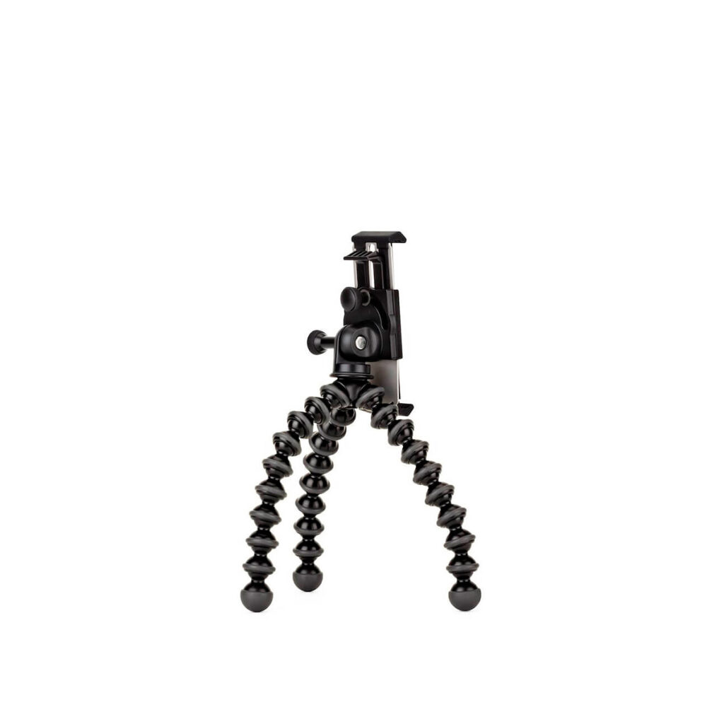 Joby GripTight GorillaPod Stand Pro Tablet JOBY GripTight GorillaPod Stand Pro Tabletille on pieni musta taipuisa kolmijalka, jossa on taivutettavat, segmentoidut jalat ja kiinnitys kameralle tai älypuhelimelle. Kuvassa se seisoo pystyasennossa valkoisella pohjalla.