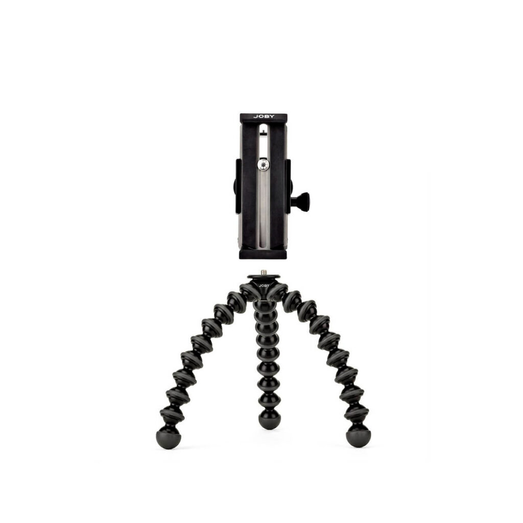 Joby GripTight GorillaPod Stand Pro Tablet3 JOBY GripTight GorillaPod Stand Pro Tabletille on kompakti musta kolmijalka, jossa on taipuisat, taivutettavat jalat ja älypuhelimen kiinnike, joka seisoo pystyssä valkoista taustaa vasten.