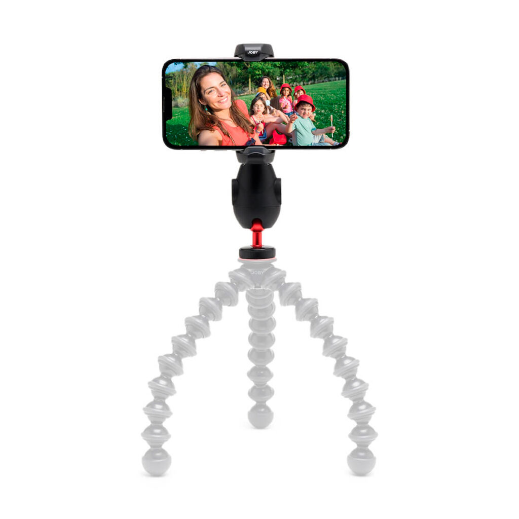 Joby-GripTight-Pro-3-2 Joby GripTight Pro 3 Phone Mount -puhelinkiinnike, jossa on valkoiset segmentoidut jalat, pitää älypuhelimen tukevasti vaakasuorassa ja näyttää hymyilevien ihmisten ryhmäselfien ulkona aurinkoisessa, vihreässä ympäristössä.