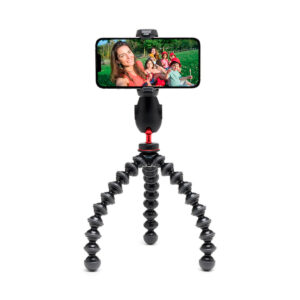 Joby-GripTight-Pro-3 kit Joby GripTight Pro 3 Kit - Phone stand, a flexible black stand with bendable, segmented legs, holds your smartphone, displaying a group selfie of smiling people outside.