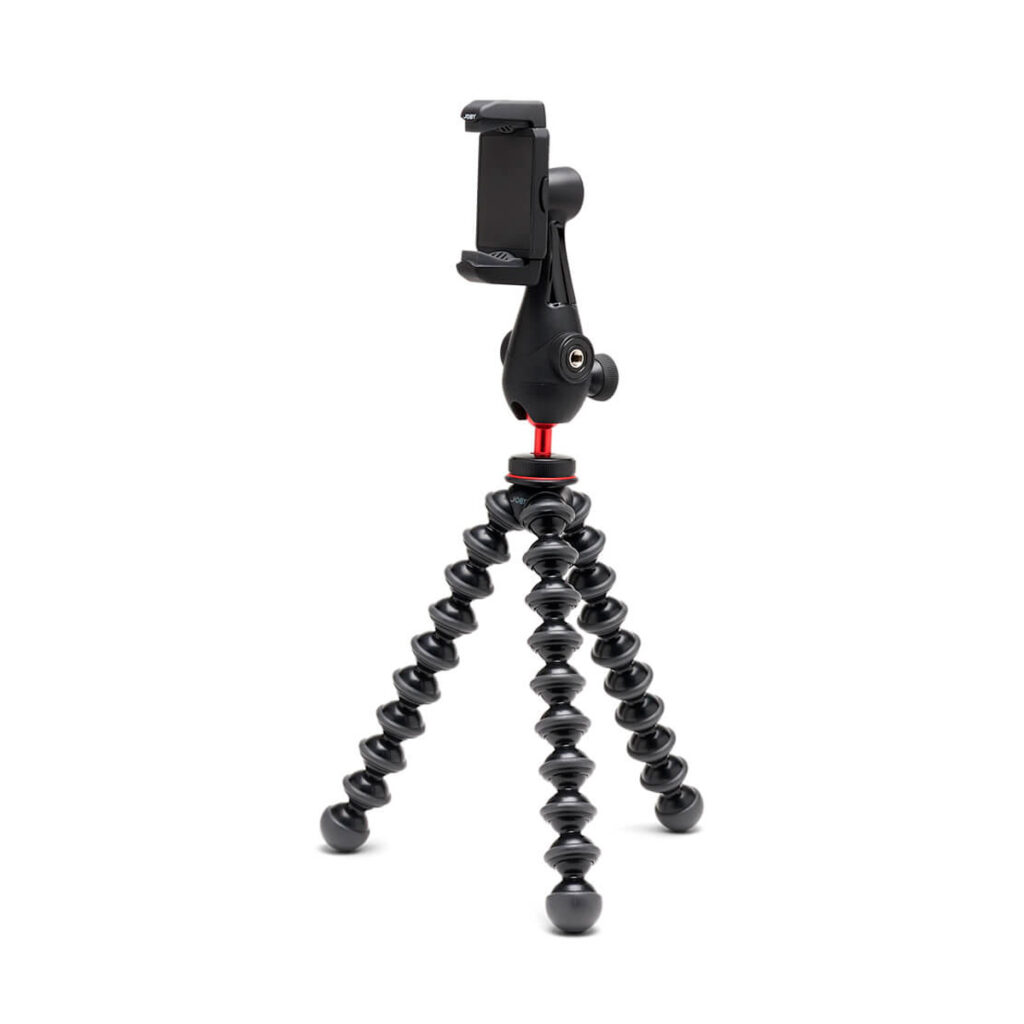Joby GripTight Pro 3 Kit - puhelinjalusta on joustava jalusta, jossa on mustat segmentoidut jalat ja älypuhelinpidike, kuvassa pystyssä valkoista taustaa vasten.