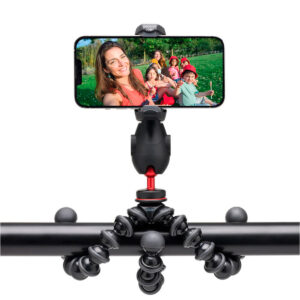 Ryhmäselfie otetaan ulkona vihreällä nurmikolla älypuhelimella, joka on kiinnitetty vaakatolppaan Joby GripTight Pro 3 Kit - puhelinjalusta, joka on asennettu joustavasti.