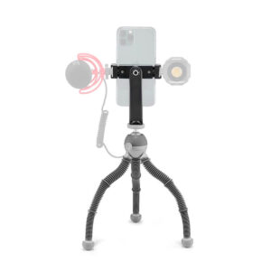 Joby PodZilla Flexible Tripod Kit M Harmaa pitää sisällään älypuhelimen, ja siinä on kiinnikkeet valinnaiselle mikrofonille ja pienelle LED-valolle, jotka on esitetty harmaalla merkiksi siitä, että ne eivät sisälly toimitukseen.