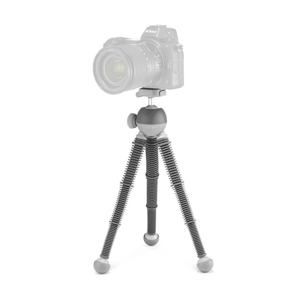 Joby PodZilla Flexible Tripod Large -jalustassa on segmentoidut jalat ja pyöristetyt jalat, jotka tukevat DSLR-kameraa turvallisesti. Kamera näyttää puoliksi läpinäkyvältä, jotta jalusta pysyy pääpainona.