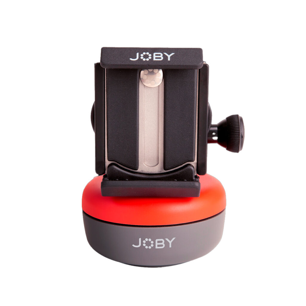 Joby-Spin-Phone-Mount-Kit Lähikuva Joby Spin Phone Mount Kit -puhelinkiinnityssarjasta, jossa on musta säädettävä kiinnike, hopeinen metallinen liukusäädin sekä punainen ja harmaa pohja valkoista taustaa vasten.