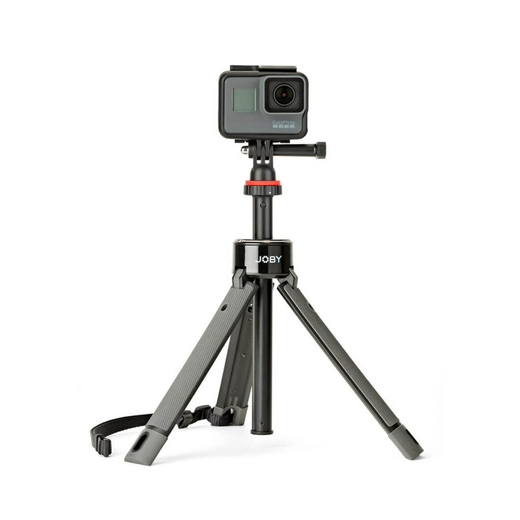 Joby-TelePod-Pro-Kit-2 Pieni musta toimintakamera on asennettu Joby TelePod Pro Kitiin, joka on kompakti kolmijalka, jossa on ulosvedettävät jalat ja kantohihna, valkoista taustaa vasten.