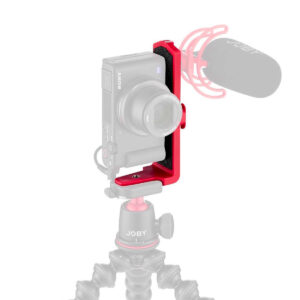 Joby-Vert-Vertical-L-Bracket-5 The Joby Vertical Vertical L Bracket, which appears bright red and fully accentuated, is mounted on a compact camera on a flexible stand with an external microphone, all against a white background, while other components appear faded.