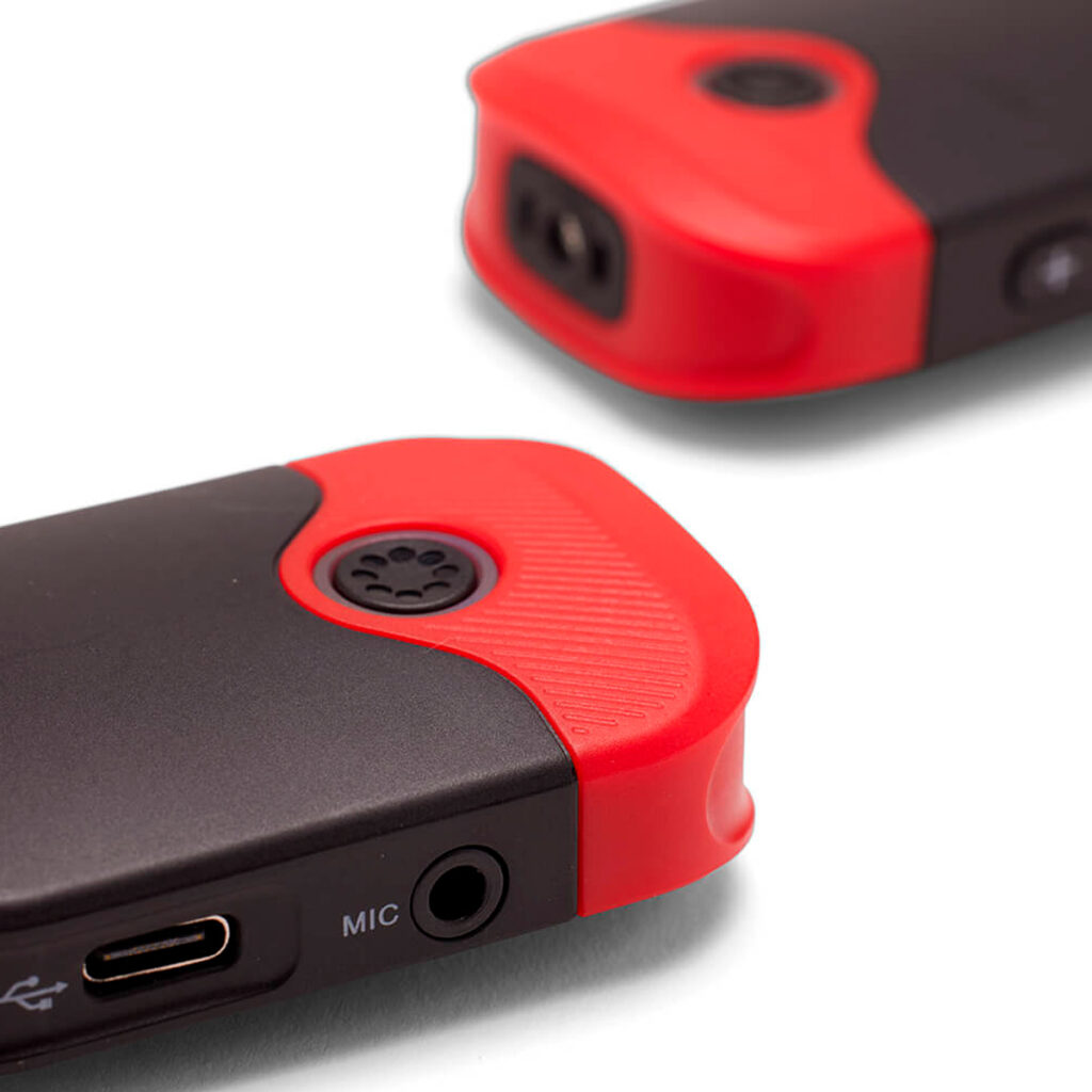 Joby-Wavo-Air-mikrofoni-5 Lähikuva kahdesta Joby Wavo Air mikrofonit mustasta ja punaisesta, joissa on kuvioidut punaiset reunat, pyöristetyt kulmat, USB-C-portti ja kuulokeliitäntä, jossa on merkintä "MIC".
