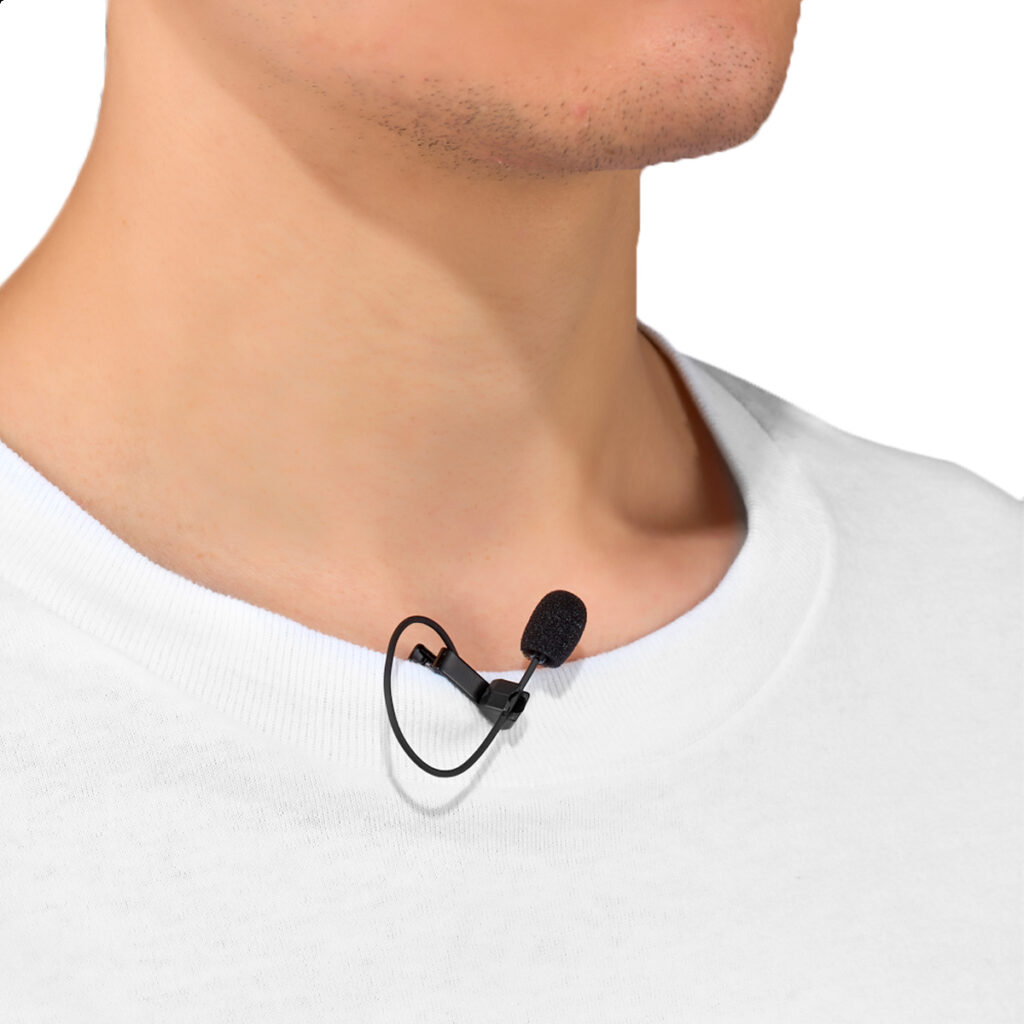 Joby-Wavo-Lav-PRO-2 Lähikuva henkilöstä, jolla on valkoinen paita ja Joby Wavo Lav PRO Mikrofoni, pieni musta lavalier-mikrofoni, joka on kiinnitetty kauluksen lähelle kaulaa.