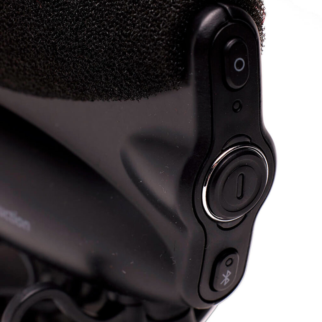 Joby-Wavo-Pro-3 Lähikuva Joby Wavo Pro - Mikrofoni -laitteen ohjauspainikkeista, joissa näkyy virtapainike, Bluetooth-painike, pyöreä painike ja kuvioitu pinta yläosassa.