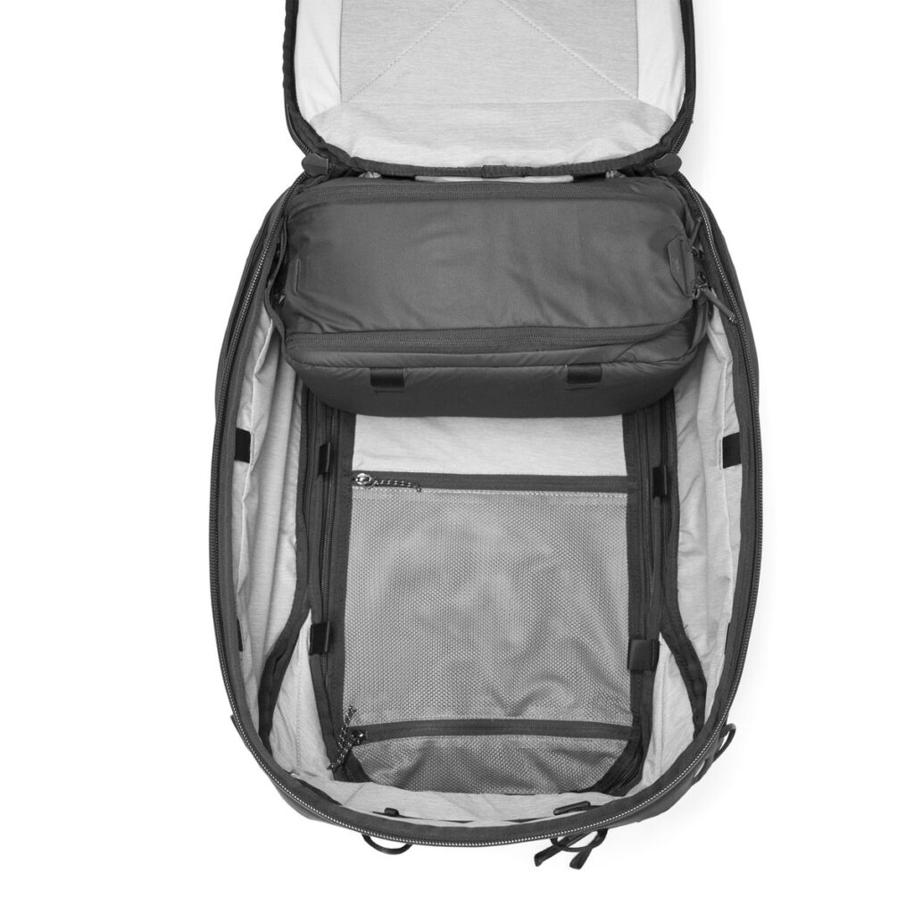 Peak-Design-Camera-Cube-small3 Ylhäältä katsottuna Peak Design Camera Cube Small -laukusta paljastuu tilava päälokero, vetoketjullinen ripustettu pussi ja sisäpuolinen verkkovetoketjullinen tasku, jotka ovat vaaleanharmaita ja joissa on mustat vetoketjut ja reunukset.