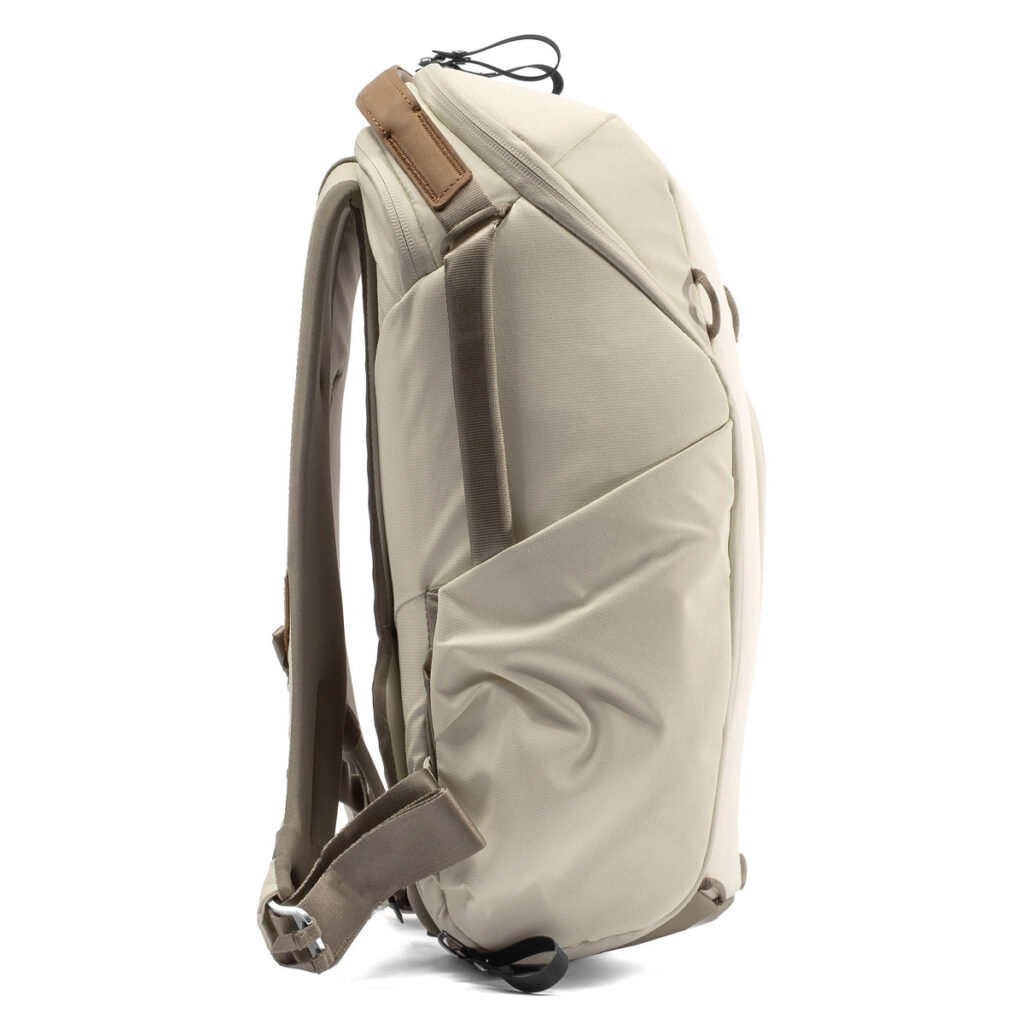 Peak-Design-Everyday-Backpack-Zip-15L-bone-3 Sivunäkymä Peak Design Everyday Backpack Zip 15L -kamerareppu Bone, jossa on pehmustetut olkahihnat, yläkahva, sivutasku ja kestävästä kankaasta valmistettu tyylikäs ja moderni muotoilu.