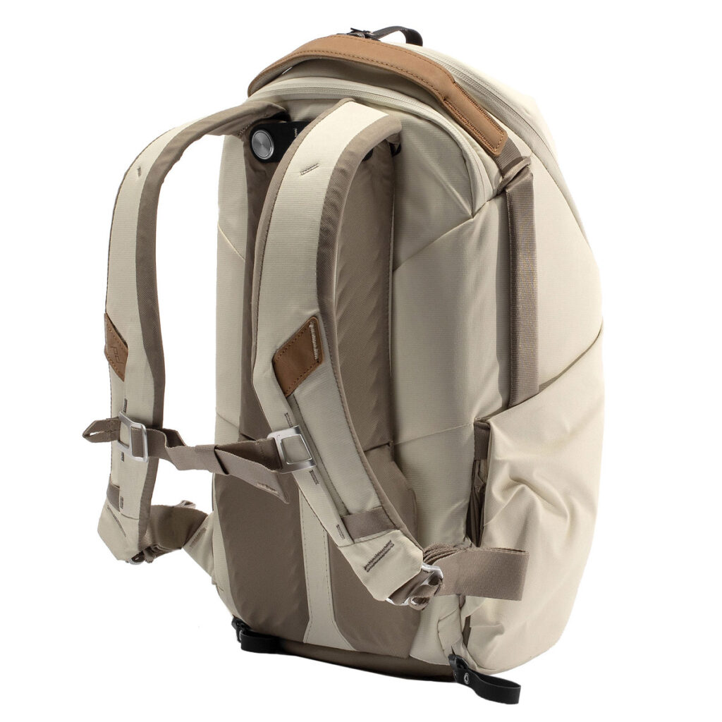 Peak-Design-Everyday-Backpack-Zip-15L-bone-5 Peak Design Everyday Backpack Zip 15L -kamerareppu Bone, jossa on pehmustetut olkahihnat, ruskeat nahkakoristeet ja rintaremmi, näkyy takaa valkoista taustaa vasten.
