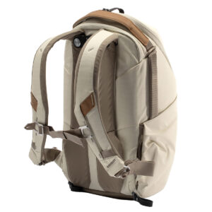 Peak-Design-Everyday-Backpack-Zip-15L-bone-5 Peak Design Everyday Backpack Zip 15L -kamerareppu Bone, jossa on pehmustetut olkahihnat, ruskeat nahkakoristeet ja rintaremmi, näkyy takaa valkoista taustaa vasten.
