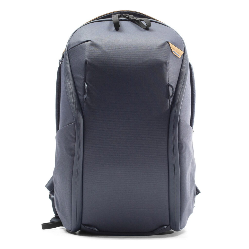 Peak-Design-Everyday-Backpack-Zip-15L-midnight-2 Peak Design Everyday Backpack Zip 15L - Midnight on tyylikäs, tummanharmaa reppu, jossa on sileä etuosa, vetoketjullinen yläsuljenta, sivutaskut, pehmustetut olkahihnat ja pieni ruskea nahkainen korostus lähellä yläosaa.