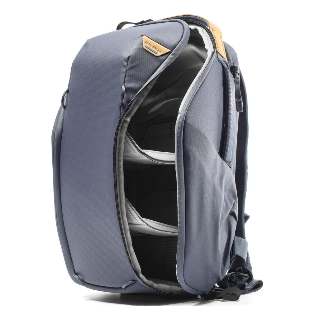 Peak-Design-Everyday-Backpack-Zip-15L-midnight-4 Peak Design Everyday Backpack Zip 15L - Midnight -repussa on tyylikäs harmaa muotoilu, jossa on pieni ruskehtava laastari yläosassa, osittain avoin vetoketju sivussa ja järjestäytyneet lokerot näkyvissä sisäpuolella.