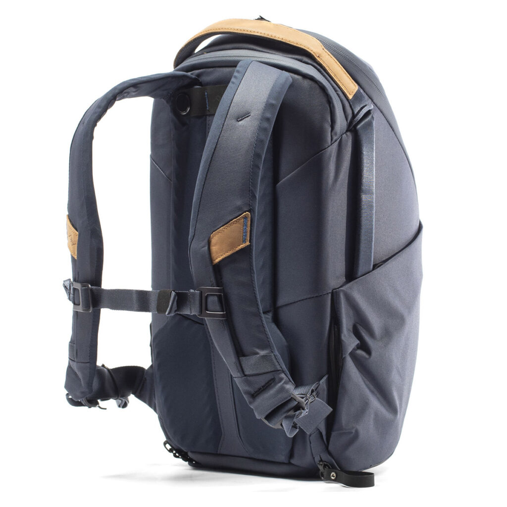 Peak-Design-Everyday-Backpack-Zip-15L-midnight-5 Peak Design Everyday Backpack Zip 15L - Midnight on tummanharmaa reppu, jossa on pehmustetut olkahihnat, ruskehtavat nahka-aksentit, rintaremmi, useita lokeroita ja moderni, rakenteellinen muotoilu, joka näkyy pystyssä valkoisella pohjalla.