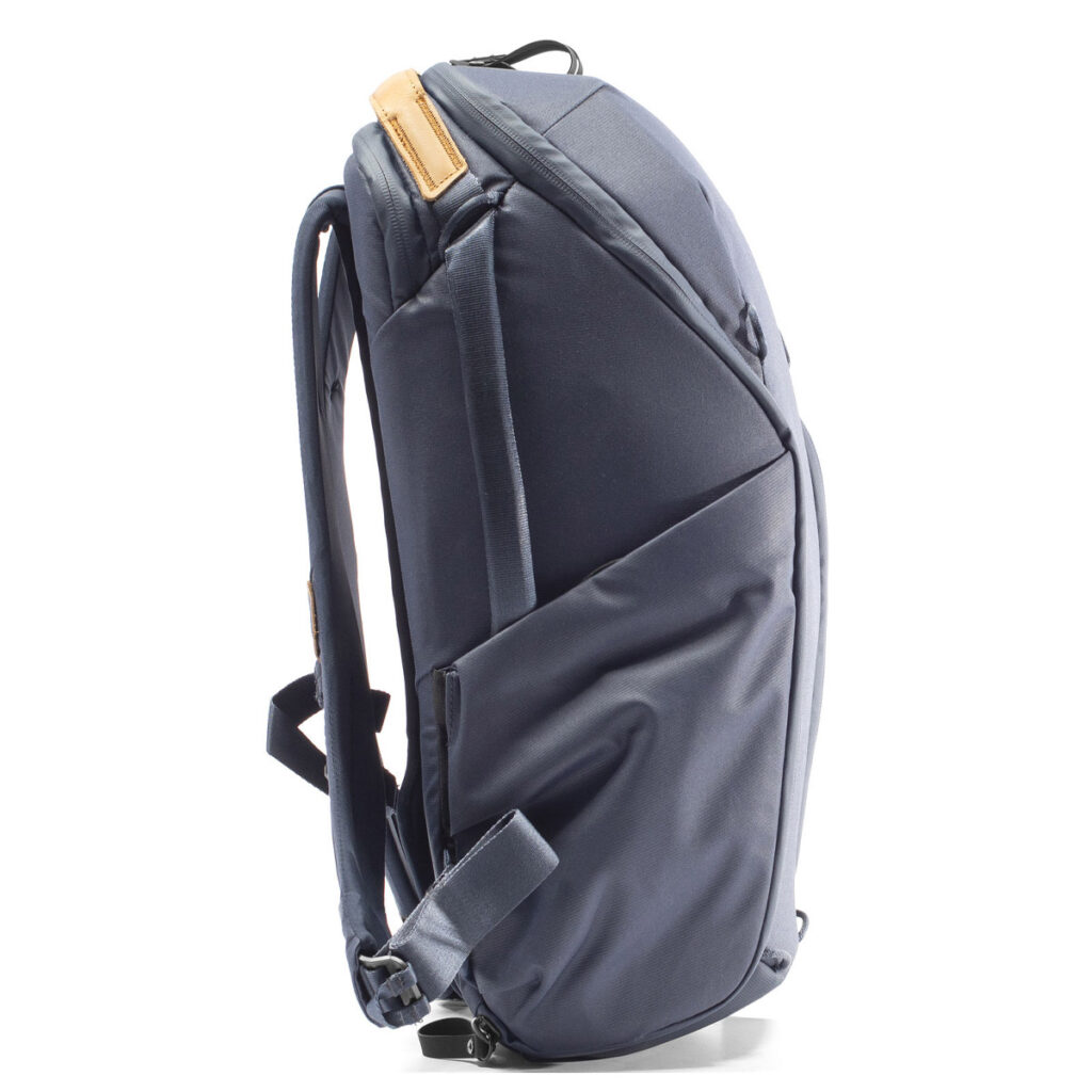 Peak-Design-Everyday-Backpack-Zip-20L-midnight-3 Peak Design Everyday Backpack Zip 20L -kamerareppu tummansinisessä sivukuvassa näkyy sen tyylikäs tummansininen muotoilu, useat lokerot, pehmustetut hihnat ja ruskehtavan sävyinen yläkahva. Reppu seisoo pystyssä valkoisella pohjalla.