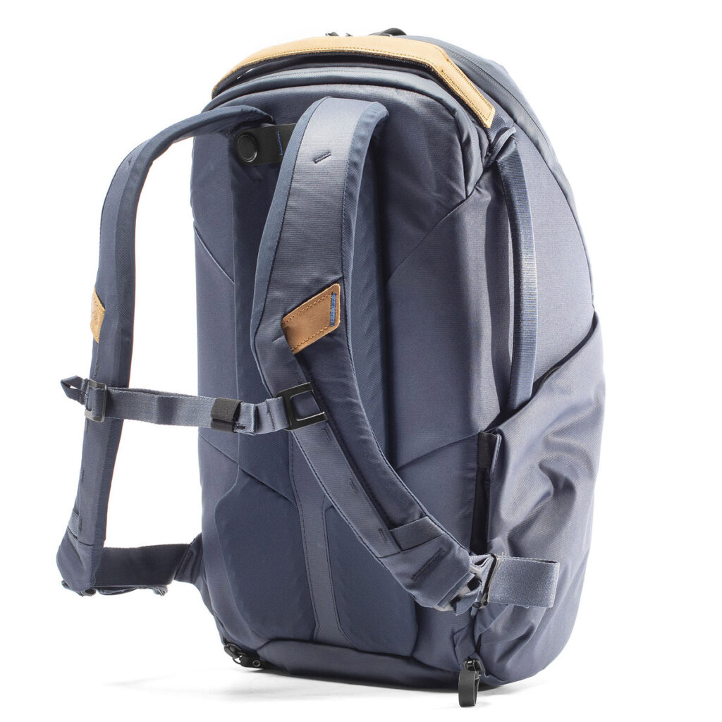 Peak-Design-Everyday-Backpack-Zip-20L-midnight-5 Peak Design Everyday Backpack Zip 20L -kamerareppu tummansinisellä värillä sisältää pehmustetut olkahihnat, rintahihnan, ruskehtavat korostukset ja modernin muotoilun, jossa on useita lokeroita ja vetoketjuja, kuvassa pystyasennossa valkoisella pohjalla.