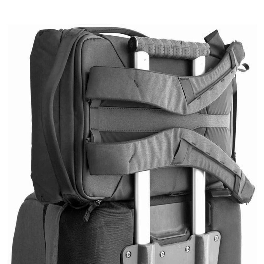 Peak-Design-Everyday-Backpack-v2-30l-black-06 Peak Design Everyday Backpack v2 30L -kamerareppu, musta on kiinnitetty turvallisesti suuremman rullalaukun teleskooppikahvaan, mikä osoittaa käytännöllisen pinoamisratkaisun matkustamiseen.