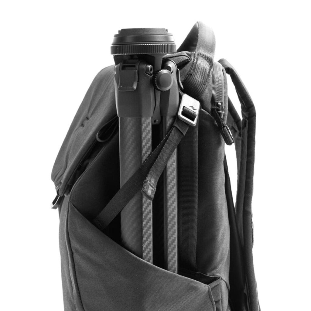 Peak-Design-Everyday-Backpack-v2-30l-black-07 Peak Design Everyday Backpack v2 30L -kamerareppu, musta, on kuvassa sivutasku, jossa on kompakti mustan ja hopeanvärinen kolmijalka, joka on kiinnitetty hihnalla, valkoista taustaa vasten.