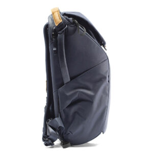 Peak-Design-Everyday-Backpack-v2-30l-midnight-4 Sivunäkymä Peak Design Everyday Backpack v2 30L -kamerareppu tummansinisessä, jossa on pehmustetut olkahihnat, yläkahva tan-aksentilla, sivutasku ja jäsennelty, hieman kaareva muotoilu.
