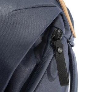 Peak-Design-Everyday-Backpack-v2-30l-midnight-6 Lähikuva Peak Design Everyday Backpack v2 30L -kamerareppu, tummansininen; ominaisuuksiin kuuluu musta vetoketju, jossa on nahkainen vetokieleke ja välähdys ruskehtavasta kahvasta oikealla ylhäällä.