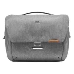 Peak-Design-Everyday-Messenger-13L-v2-Ash-1 Peak Design Everyday Messenger 13L V2 - Ash on harmaa, moderni messenger-laukku, jossa on läppäsuljenta, nahkainen aksentti, minimalistinen metallilaitteisto, pehmeä kangasrakenne ja tukeva yläkahva.