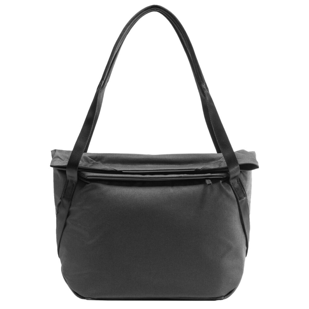 Peak-Design-Everyday-Tote-15l-black-1 Mustassa Peak Design Everyday Tote 15L v2 -laukussa on pitkät olkahihnat, vetoketjullinen etutasku, tyylikäs moderni muotoilu ja sileä kangas. Kuvassa valkoista taustaa vasten.