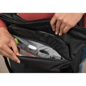 Peak-Design-Everyday-Tote-15l-black-6 Henkilö avaa Peak Design Everyday Tote 15L v2 - Black -laukun, josta paljastuu järjestettyjä lokeroita, joihin mahtuu siististi puhelin, latauskaapelit, langattomat kuulokkeet, korostuskynä ja muita pieniä esineitä.