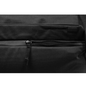 Peak-Design-Everyday-Tote-15l-black-7 Lähikuvassa Peak Design Everyday Tote 15L v2 mustana, jossa on vetoketjullinen tasku, jossa on kankainen vetokieleke läpän alla. Laukussa on sileä, kestävä rakenne.