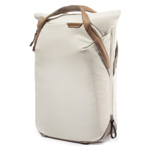 Peak-Design-Everyday-Totepack-20l-bone-3 Peak Design Everyday Totepack 20L v2 in Bone on moderni, minimalistinen vaaleanbeige reppu, jossa on ruskehtavat nahkakahvat sekä sivu- ja ylävetoketjut, kuvassa valkoista taustaa vasten.