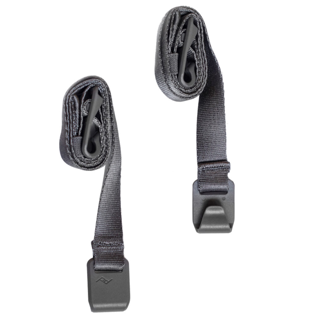 Peak-Design-External-Carry-Strap-V2-long-ash-1 Kaksi Peak Design Spareparts V2 -ulkoista kantohihnaa (pitkä, tuhka), joissa on muovisoljet, näytetään rullattuina vierekkäin valkoisella pohjalla.