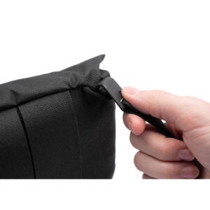 Peak-Design-Field-Pouch-V2-black-6 Lähikuva kädestä vetämässä vetoketjua Peak Design Field Pouch V2 - Black -laukussa, jossa korostuvat vetoketju ja kuvioitu musta kangas.
