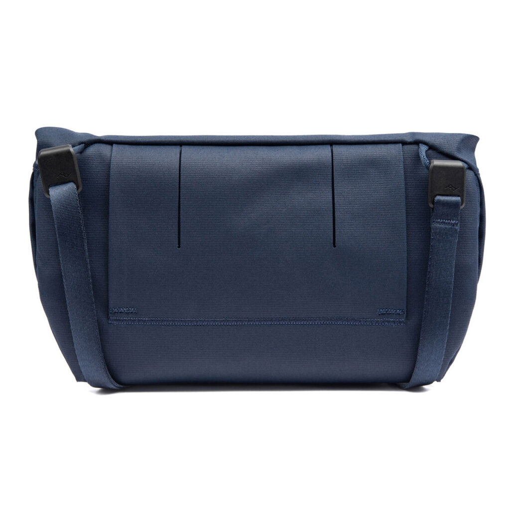Peak-Design-Field-Pouch-V2-midnight-3 Peak Design Field Pouch V2 - Midnight on laivastonsininen laukku, jossa on yksinkertainen suorakulmainen muotoilu, kaksi mustaa sivusolkea, säädettävä hihna, sileä ulkokangas ja kaksi pystysuoraa etusaumaa.